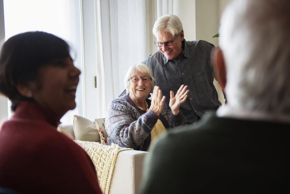 Senior people are talking in a living room